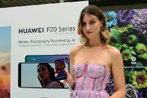 法国巴黎，模特在发布会上展示华为新品P20系列手机