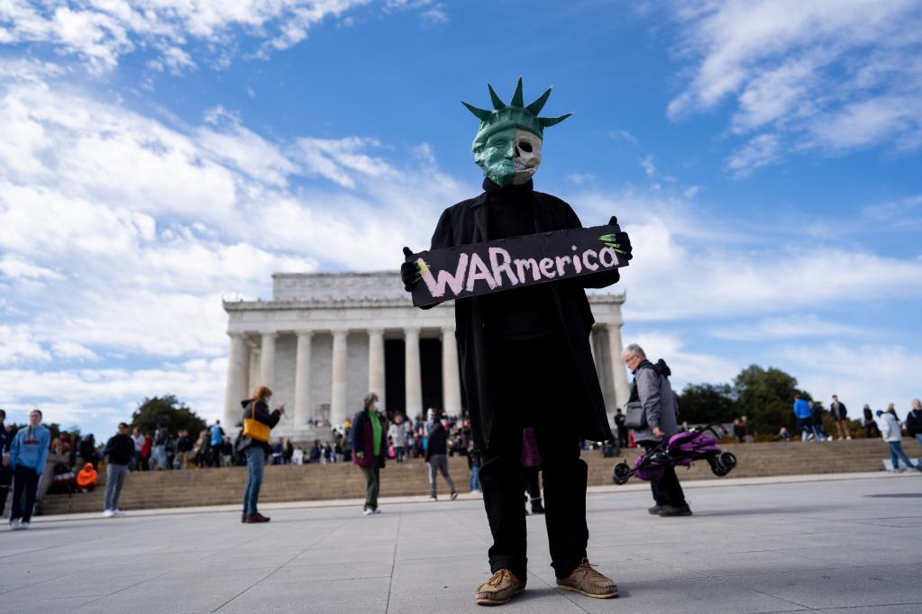 美国首都华盛顿，一名抗议者手举标语在林肯纪念堂前参加反战集会