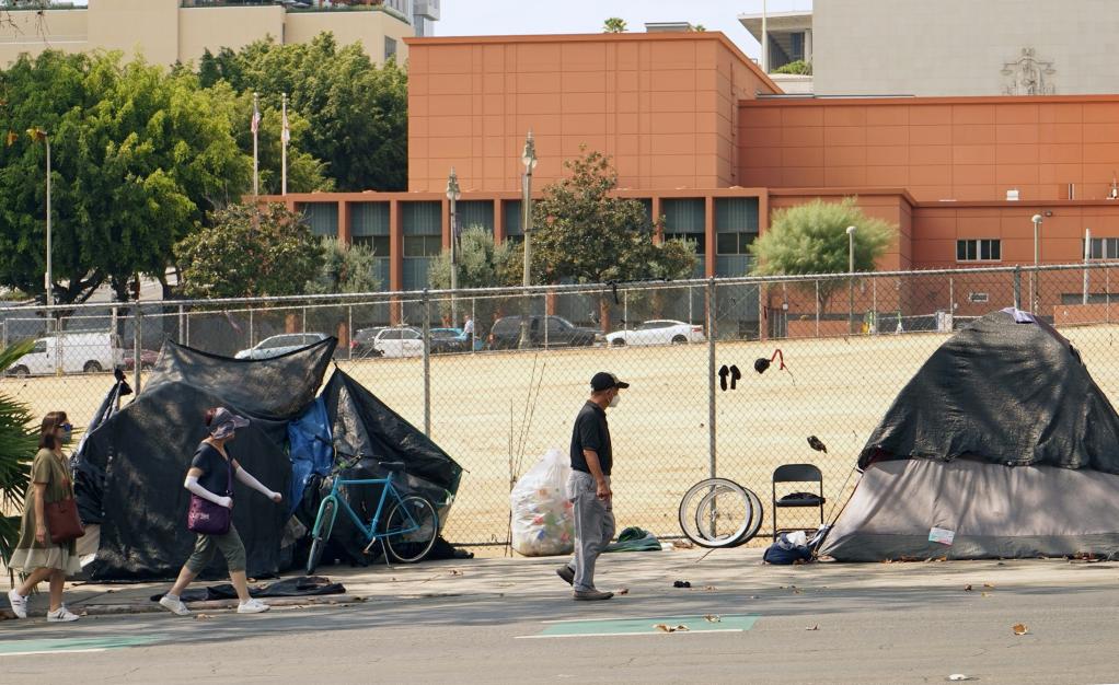 人们在美国加利福尼亚州洛杉矶市区经过无家可归者的帐篷