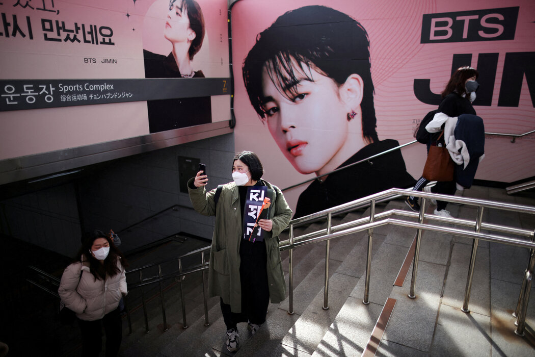 一位歌迷在首尔奥林匹克体育场举行的防弹少年团演唱会广告前自拍