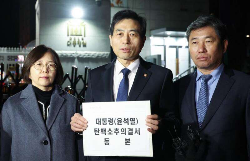 国会议长禹元植通过国会事务总长金民基（中），以及共同民主党议员赵五燮等，向龙山方面递交了《总统（尹锡 ...