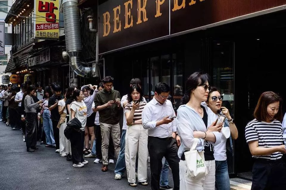 韩国首尔，人们在投票站前排起长队，进行总统选举的提前投票