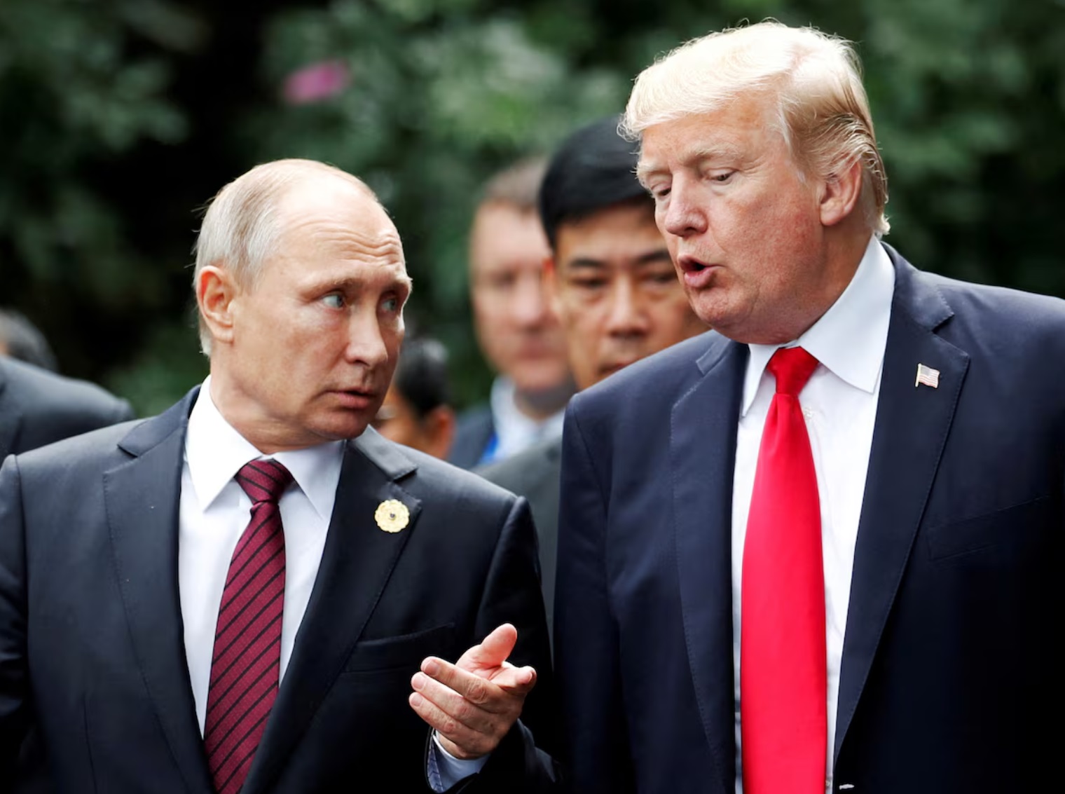 美国总统唐纳德·特朗普和俄罗斯总统弗拉基米尔·普京在越南岘港亚太经合组织峰会的家庭合影中交谈 ...